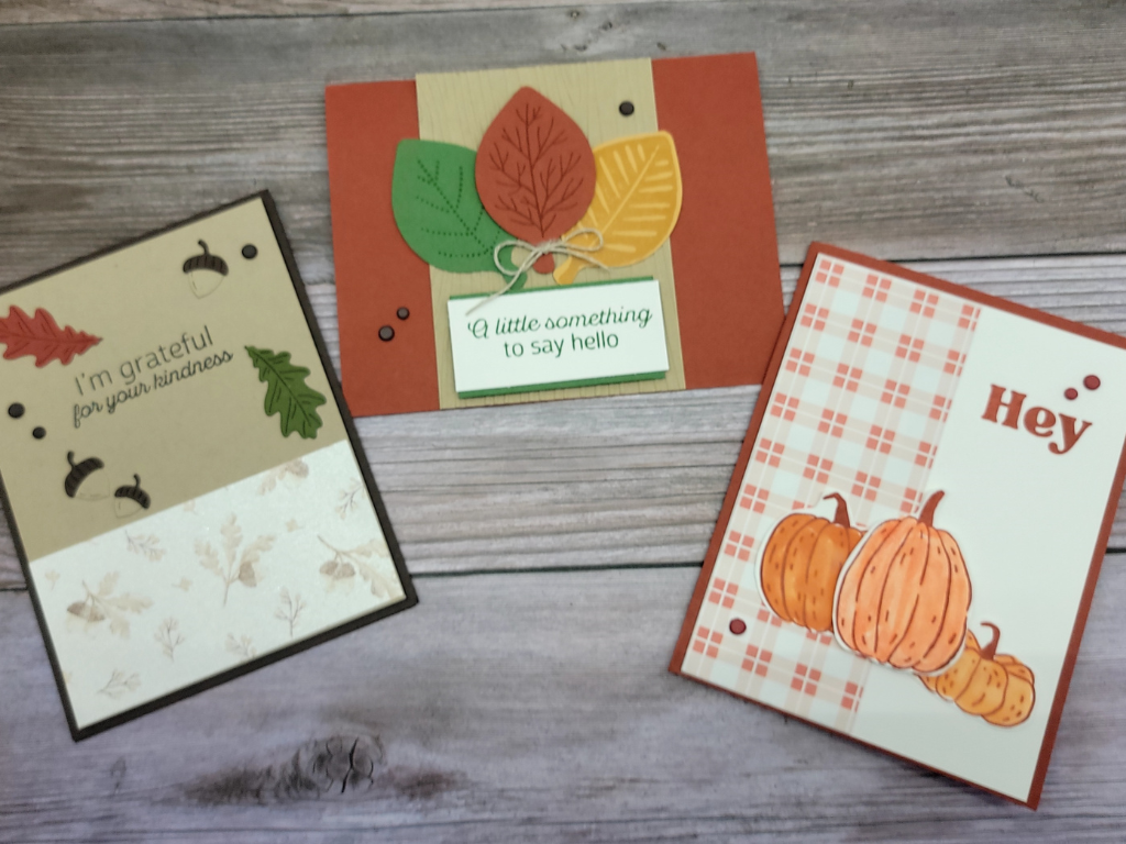 Photo of three greeting cards in orange, gold, and green colors.